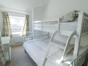 a bedroom with two bunk beds with a ladder at The Harbour in Rhosneigr