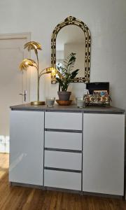 a white dresser with a mirror on top of it at Nid douillet dans le village de Marcillac-Vallon in Marcillac-Vallon