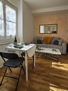 a living room with a table and a couch at Nid douillet dans le village de Marcillac-Vallon in Marcillac-Vallon +10 photos