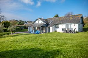 a house with a large lawn in front of it at Family-friendly Bungalow Near Thurlestone Beach in Thurlestone