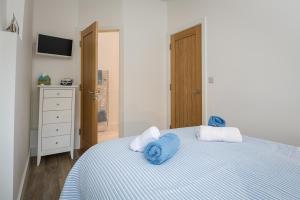 ダートマスにあるCharming Apartment With Garden & Parkingの青いタオルが敷かれたベッドのある寝室