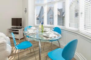 ダートマスにあるCharming Apartment With Garden & Parkingのダイニングルーム(ガラステーブル、青い椅子付) +13枚の写真