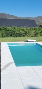 a large swimming pool with a blue at La Macarena Suites in Villa General Belgrano