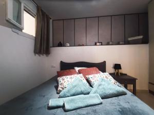 a bedroom with a bed with pillows on it at S & D apartment in Heraklio Town