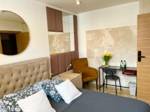 Un dormitorio con una cama, un escritorio y un espejo. en North Nest Luxury Suites, en Gdansk