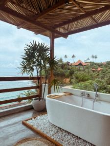 Un baño con bañera y vista al mar. en Ocean Bliss by Sugar Coliving, en Weligama