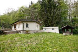 a small house in a yard with a grass yard at Häuserl am Wald in Leibnitz