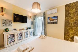 a bedroom with a bed and a tv on the wall at Palaiopolis Maison by Konnect, Mon Repos Corfu in Corfu Town +4 photos