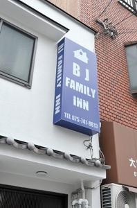 una señal de posada familiar azul en el lateral de un edificio en BJ family inn en Kyoto