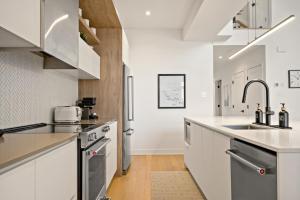 a kitchen with white cabinets and a sink at Tremblant Prestige Verbier 6 202 in Mont-Tremblant