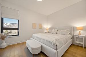 a white bedroom with a large bed and a window at Tremblant Prestige Verbier 6 202 in Mont-Tremblant +30 photos