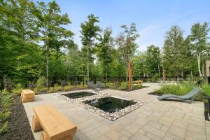a patio with a table and chairs and a pond at Tremblant Prestige Verbier 6 202 in Mont-Tremblant