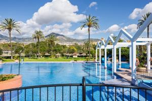 basen w ośrodku z palmami w obiekcie BenalBeach Premium Apartments by Alfresco Stays w mieście Benalmádena
