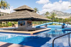 duży basen z dużym parasolem obok ośrodka w obiekcie BenalBeach Premium Apartments by Alfresco Stays w mieście Benalmádena