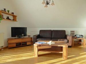 a living room with a leather couch and a coffee table at Ferienwohnung-3-im-Haus-Baltique in Glowe