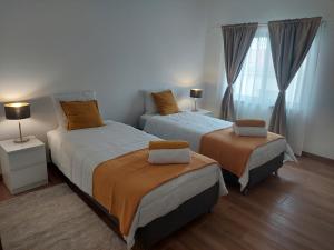 a bedroom with two beds and a window at Casa Loja do Xavier in Ponta Delgada