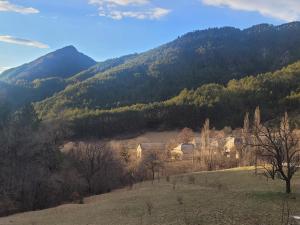 a village in a field with mountains in the background at Terre Rouge in Boulc
