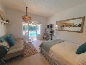 a bedroom with a bed and a couch and a mirror at Plett Pool Villa in Plettenberg Bay