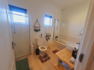 a bathroom with a white toilet and a sink at Plett Pool Villa in Plettenberg Bay