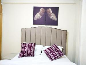 een bed met twee kussens en twee engelenvleugels bij Cutie homes -Trm drive in Nairobi