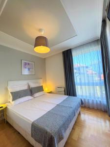 Un dormitorio con una cama grande y una ventana grande en Dunav Apartment House, en Sofía