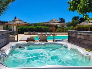 bañera de hidromasaje en un patio junto a la piscina en Hôtel Padolo, en Bonifacio