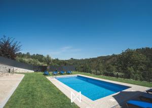 una piscina en medio de un patio con césped en MyStay - Vieira's Guest House, en Vieira do Minho