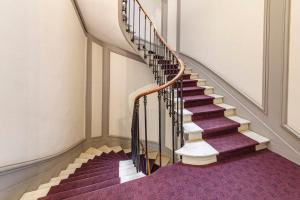 una escalera de caracol en un edificio con alfombra morada en Le Roi René - XIXe siècle - Château, en Angers