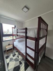 two bunk beds in a room with a window at Departamento nuevo para 5 personas in Temuco