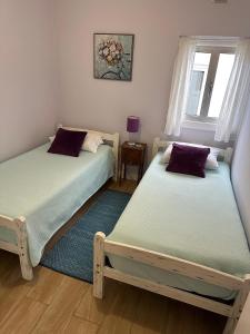 two twin beds in a room with a window at Rose's Cottage Foz in Foz do Arelho