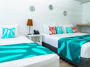 圣安德烈斯Hotel Caribbean Coral的一间白墙房间里有两张床