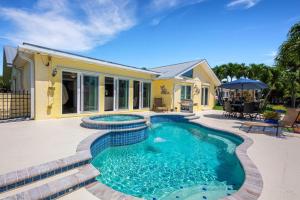 a house with a swimming pool in front of a house at Casa Palmera by SkyRun Anna Maria in Bradenton