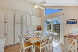 a dining room with a table and chairs and a ceiling fan at Casa Palmera by SkyRun Anna Maria in Bradenton