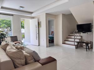 a living room with a couch and a tv at Casa 404 - Aconchegante a 350m do mar em Bombas - Ideal para famílias! in Bombinhas