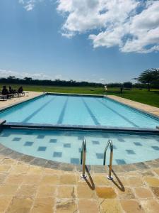 a large blue swimming pool with two metal handles at Sangare Hills Country Homes & Resort in Mweiga