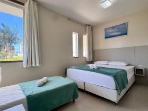 a bedroom with two beds and a window at Casa 404 - Aconchegante a 350m do mar em Bombas - Ideal para famílias! in Bombinhas