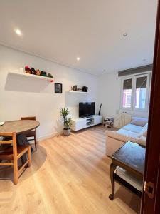 a living room with a table and a couch at Habitación cerca del centro, baño y cocina compartida in Bilbao