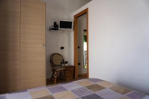 een slaapkamer met een bed en een stoel naast een deur bij La casetta rosa in Nicotera