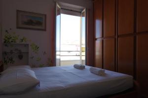 a bedroom with a bed with two towels on it at La casa di Greta in Marcelli +6 photos