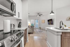 a kitchen with a sink and a stove top oven at Vibrant 1 Bedroom Paradise Pool and Gym Bliss in Apollo Beach