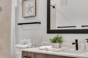 a bathroom with a sink and a mirror at Vibrant 1 Bedroom Paradise Pool and Gym Bliss in Apollo Beach
