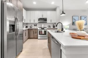 a kitchen with stainless steel appliances and wooden cabinets at Vibrant 1 Bedroom Paradise Pool and Gym Bliss in Apollo Beach