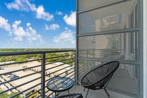a balcony with two chairs and a view of the ocean at Live the Downtown Life Cozy 1 Bed Near Tropicana in St Petersburg