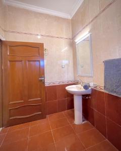 a bathroom with a sink and a wooden door at 3 BDR F10-1 Escape in Islamabad
