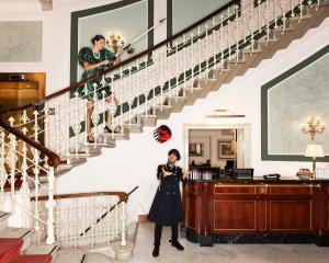 a woman standing on the stairs of a house at Hotel Bristol Palace in Genoa