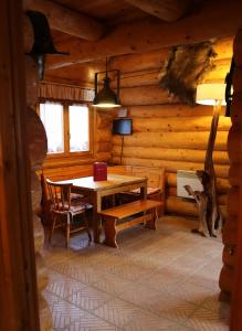 ein Esszimmer in einem Blockhaus mit einem Tisch und Stühlen in der Unterkunft Gite En Rondins in Janvry