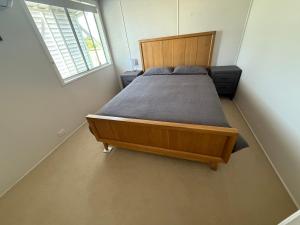 a bedroom with a bed in a room with a window at 3 bedrooms plus study unit upstairs in Bowen