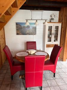 a dining room with a table and red chairs at Ferienhaus Vita in Extertal