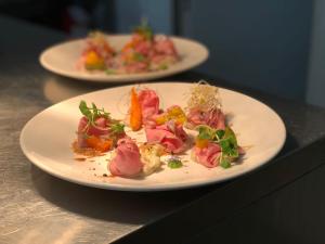 two plates of food sitting on a table at Friciulin - guest house con ristorante restaurant in Lesegno