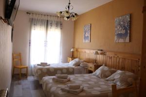 une chambre d'hôtel avec deux lits et une fenêtre dans l'établissement Casa Rural La Cerecera, à Los Navalucillos